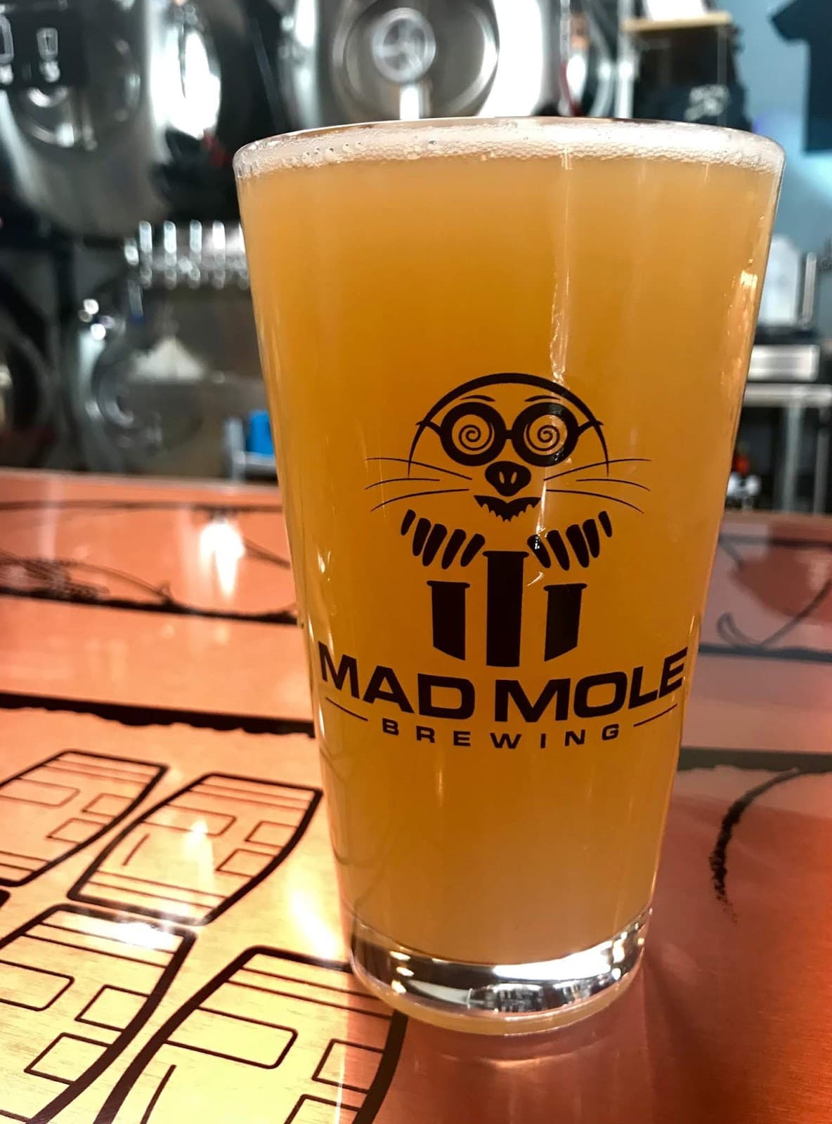 A hazy IPA in a branded Mad Mole Brewing pint glass